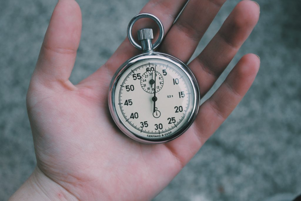 person holding white and silver-colored pocket watch because you hold all the time you need in your hand