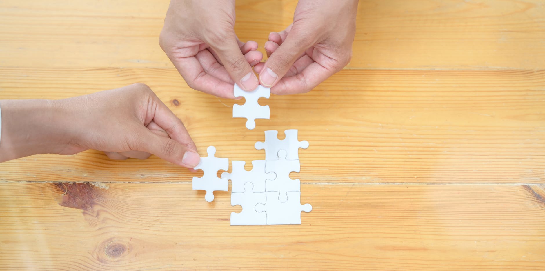 person holding white jigsaw puzzle piece