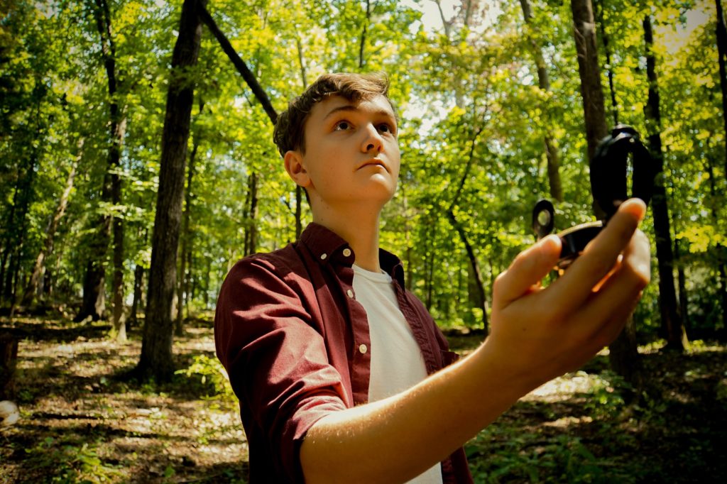 Teen in the woods using a compass is where a step-dad can come into play as a mentor