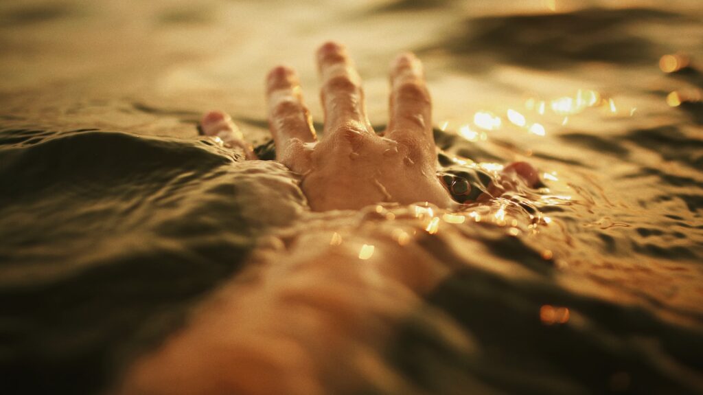 persons hand on brown textile