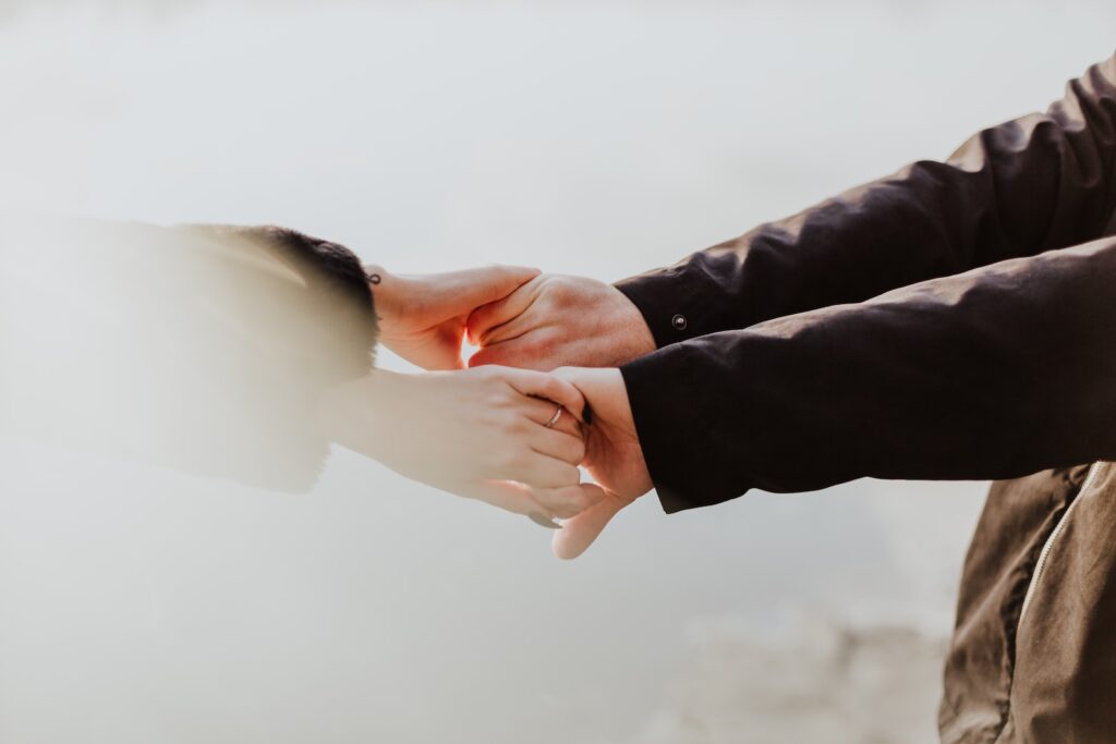 a couple holding hands while standing next to each other