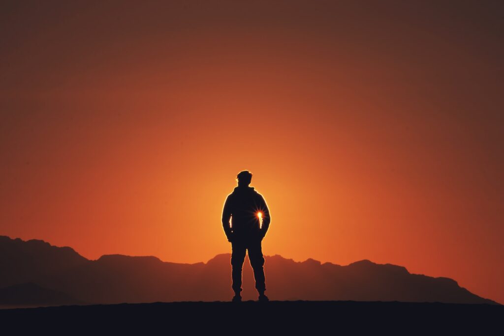 silhouette photography of person standing on platform with mountain background during golden hour
The purpose will propel you to levels you never thought of