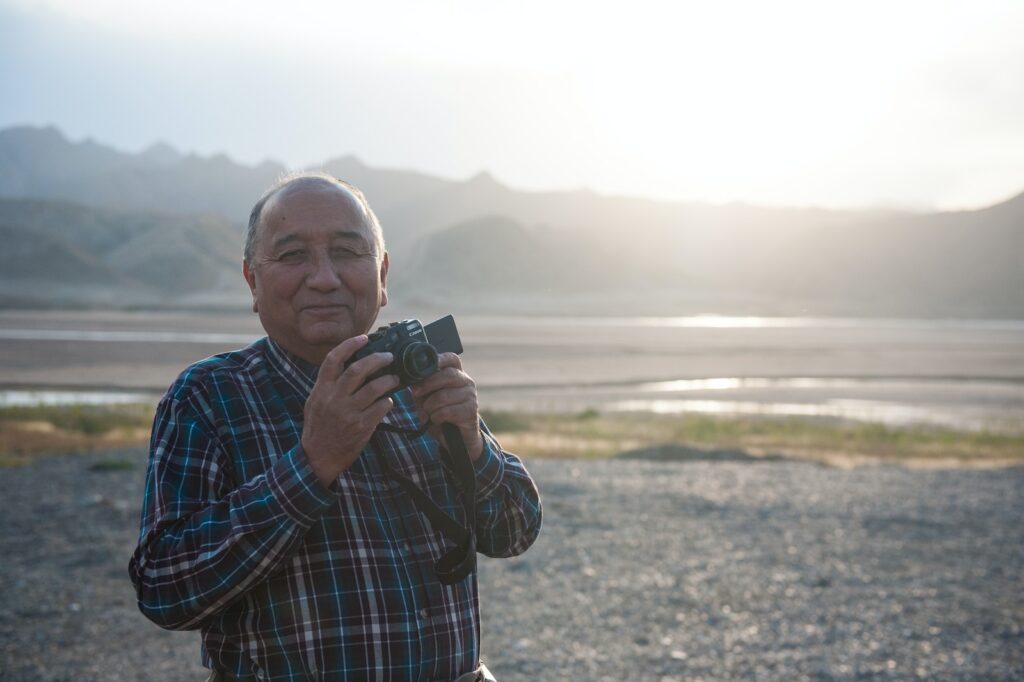 man in red white and black plaid dress shirt holding black camera.

Our purpose is to create